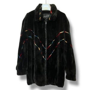 May include: Black faux fur coat with a zip-up front and a collar. The coat features colorful zigzag accents in red, yellow, and blue. The label reads "Affinity".