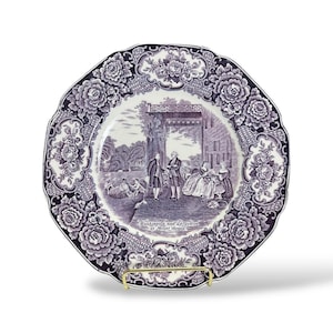 May include: A decorative plate with a scalloped edge and a floral border in shades of purple and white. The center features a historical scene with figures and the text "Washington and Lafayette at Mount Vernon."