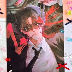 May include: A rectangular art print featuring an anime-style illustration of a person with dark hair, wearing a white shirt and black tie, with red accents and blood-like markings on their face and clothing, surrounded by small colourful bows.