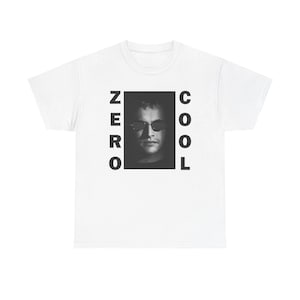 May include: White t-shirt featuring a black and white image of a person wearing sunglasses, with the words "ZERO COOL" printed in black on either side of the image. The shirt is a classic crew neck style.