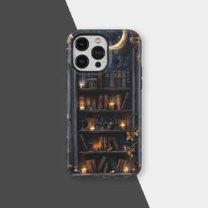 May include: A phone case with a detailed illustration of a bookshelf filled with books and lit candles. The design includes a crescent moon and stars, creating a mystical and cosy aesthetic. The case has a dark, moody colour palette.