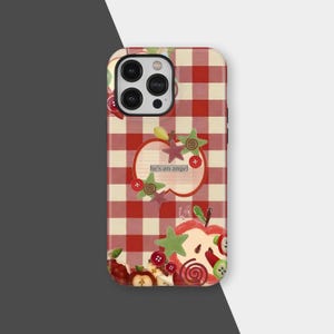 May include: A phone case with a red and cream gingham pattern. The case features apple and star embellishments, along with the text "he's an angel". Decorative buttons and a swirl candy are also included in the design.