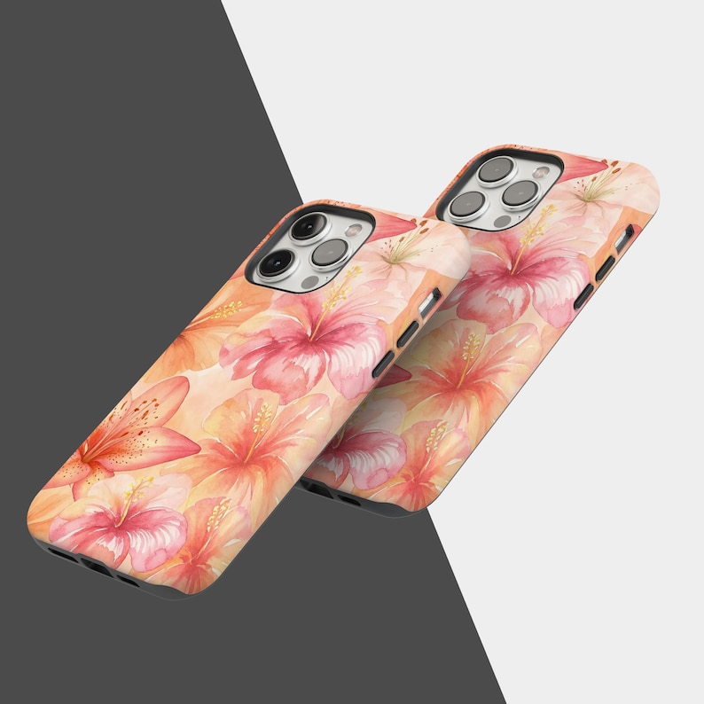 Puede incluir: Dos fundas para tel&eacute;fono con un dise&ntilde;o floral. Las fundas presentan un patr&oacute;n de acuarela de flores de hibisco y lirios rosas y naranjas sobre un fondo melocot&oacute;n. Las fundas tienen una lente de c&aacute;mara negra y botones laterales.
