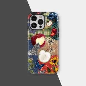 May include: A colorful phone case featuring a collage of illustrations. The design includes a red apple with a heart-shaped cutout, a small dog, bees, butterflies, a sunflower, and blueberries. The background is a patchwork of patterns.