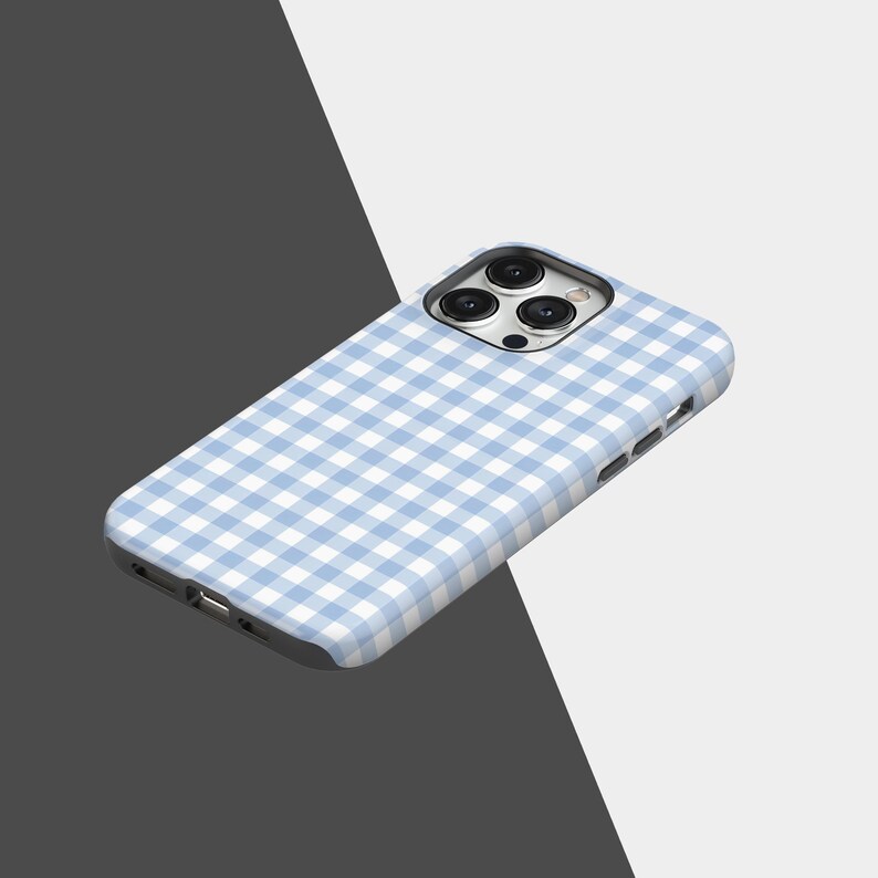 May include: A light blue and white gingham patterned phone case. The case is designed to fit a smartphone, with cutouts for the camera and charging port. The case is made of a hard, protective material.