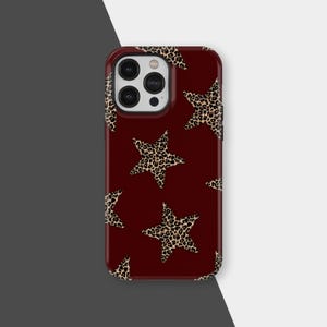 May include: A maroon phone case featuring a repeating pattern of leopard print stars. The case has a glossy finish and a dark maroon background. The stars are a tan and brown leopard print.
