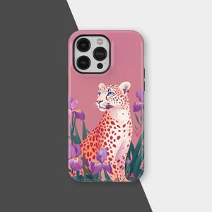 May include: A pink phone case featuring a leopard illustration with purple irises. The leopard has a white and tan coat with red spots and blue eyes. The case has a glossy finish and a camera cutout.
