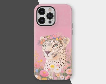 May include: Pink phone case featuring a leopard with a floral crown, surrounded by colorful flowers. The leopard has a white coat with black spots and green eyes. The case has a black camera module.