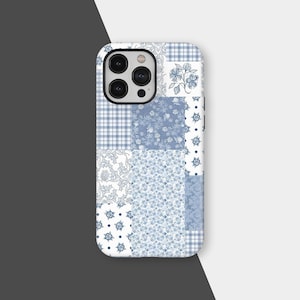 May include: A phone case with a patchwork design in shades of blue and white. The case features various patterns, including floral, gingham, and geometric shapes. The camera lenses are visible at the top. The overall aesthetic is a mix of vintage and modern styles.