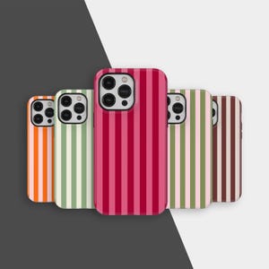 Puede incluir: Cinco fundas para teléfono con diseños de rayas verticales. Las fundas presentan una variedad de colores, incluyendo naranja, verde, rosa y marrón. Cada funda tiene un recorte para la cámara y un diseño elegante.