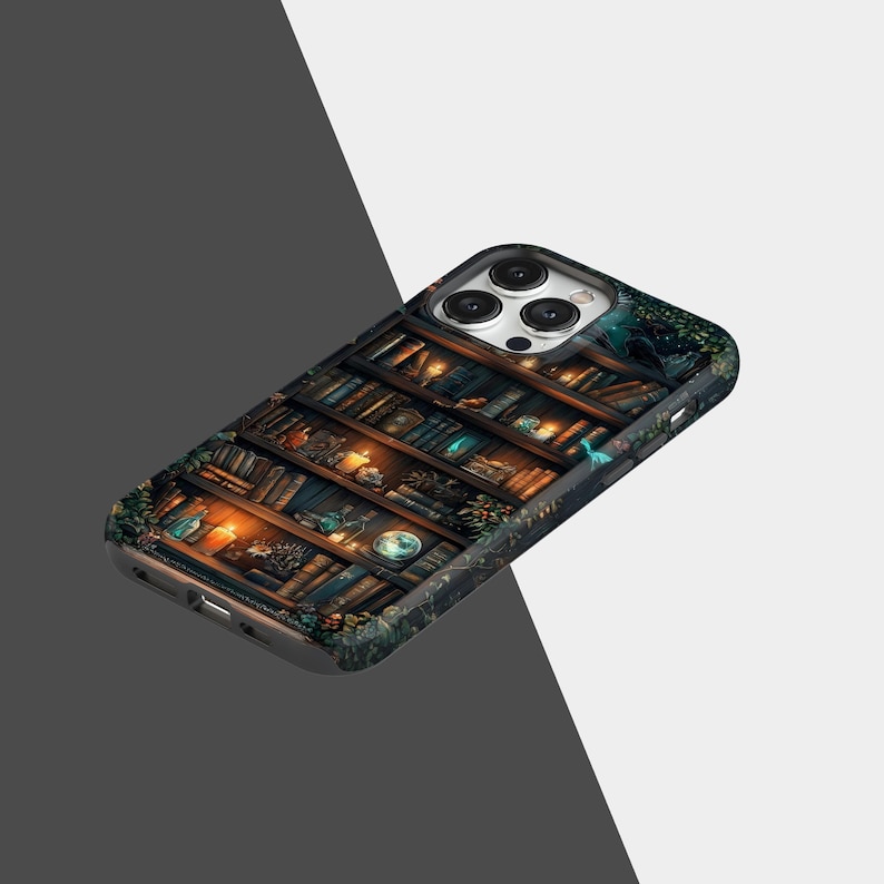 May include: A phone case featuring a detailed illustration of a bookshelf filled with books, candles, and decorative items. The case has a dark, textured background with a fantasy theme. The design includes warm, inviting colors.