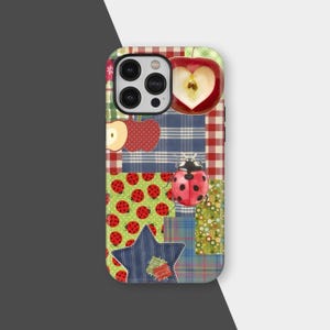 May include: A colorful phone case with a patchwork design. The case features a red apple with a heart-shaped core, a ladybug, and a blue star. The background includes plaid, polka dots, and floral patterns. The case is designed to fit a smartphone.