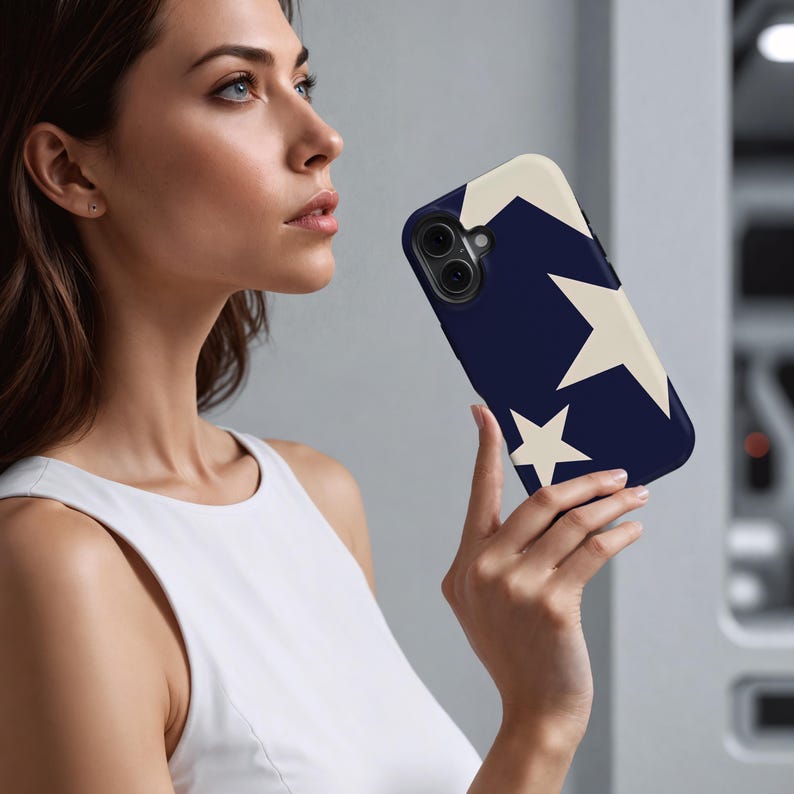 May include: A navy blue phone case featuring a cream-colored star design. The case has a smooth finish and is designed to fit a smartphone. The stars are of varying sizes and are arranged on the back of the case.