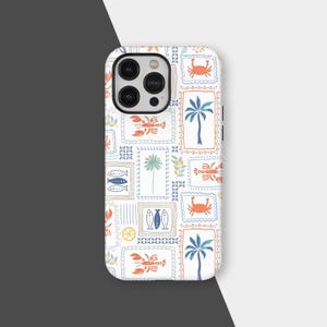 Op de afbeelding: Witte telefoonhoes met een herhalend patroon van zeedieren en tropische elementen. Het ontwerp bevat krabben, kreeften, vissen en palmbomen in oranje, blauw en groen, tegen een witte achtergrond.