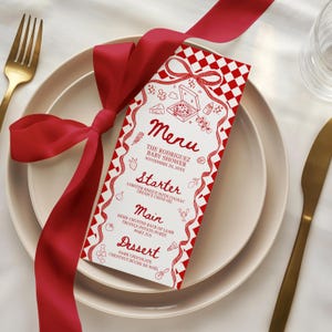 May include: A baby shower menu card with a red and white checkered border and bow design. The menu lists starter, main, and dessert courses. A red ribbon is tied around the card and a white plate. A gold fork and knife are on the side.