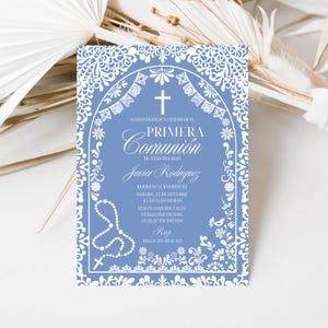 Könnte beinhalten: Eine rechteckige Einladungskarte in Kornblumenblau mit weißen, komplizierten, spitzenartigen Randmustern. Das Design zeigt einen zentralen Bogen, ein Kreuz und eine Rosenkranzgrafik. Der Text enthält ACOMPAÑANOS A CELEBRAR EL PRIMERA COMUNIÓN.