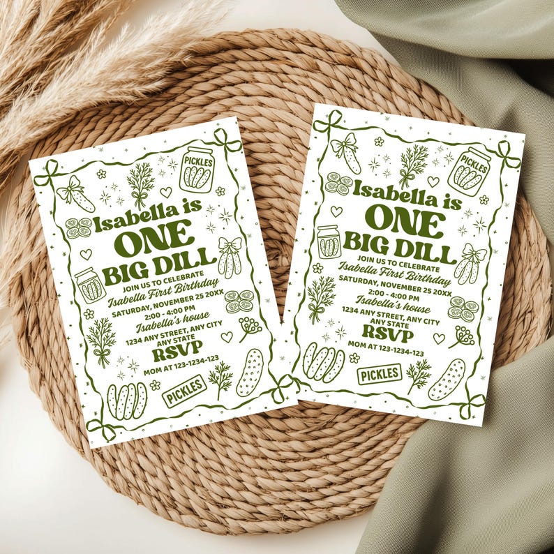 May include: Two green and white invitations for a birthday party. The text on the invitations reads "Isabella is ONE BIG DILL" with pickle-themed illustrations. Includes party details and RSVP information.