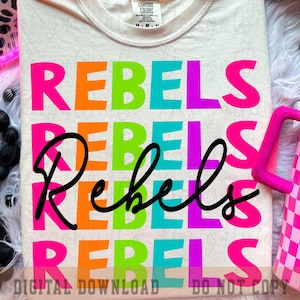 Op de afbeelding: Crèmekleurig T-shirt met het woord "REBELS" in grote, kleurrijke blokletters: roze, oranje, groen, turquoise en paars. Een zwart "Rebels" in cursief staat over de blokletters. De woorden "DIGITALE DOWNLOAD" en "NIET KOPIËREN" staan onderaan.