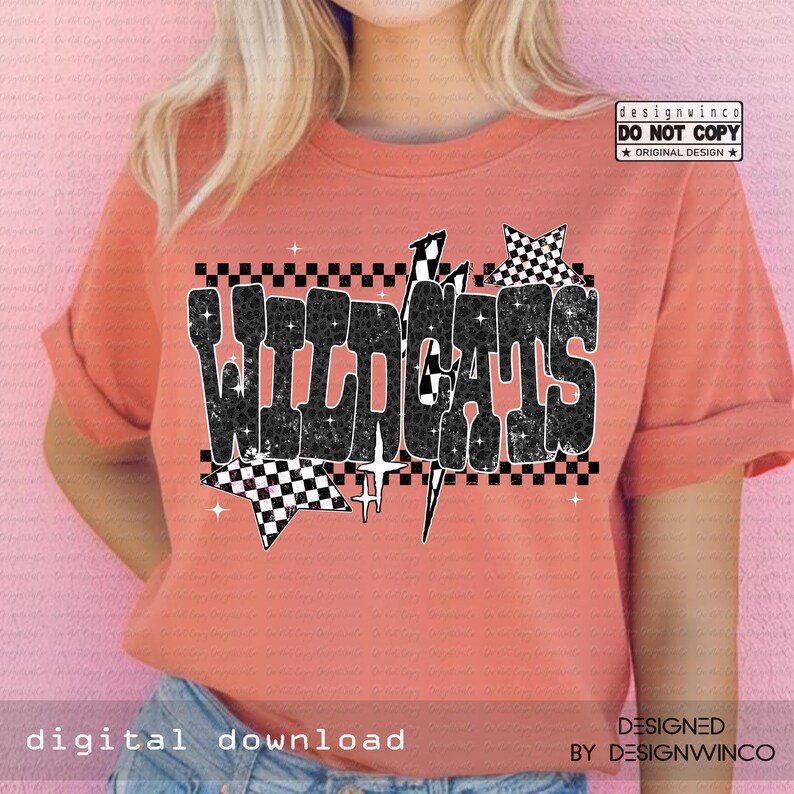 Pode incluir: Uma camiseta coral com a palavra "WILDCATS" em um design xadrez preto e branco desgastado. O design inclui estrelas e raios. A camisa tamb&eacute;m tem o texto "digital download" e "DESIGNED BY DESIGNWINCO".