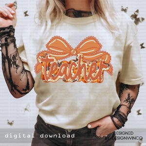 May include: Cream-colored t-shirt with an orange bow and the word "Teacher" in a fall-themed design. The text is outlined in orange and filled with a pumpkin pattern. The words "digital download" are at the bottom.
