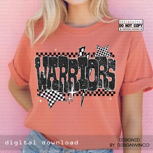 May include: Coral-colored t-shirt with the word "WARRIORS" in a black and white checkered design. The design includes stars and lightning bolts. The shirt has rolled-up sleeves and is made of a soft material.
