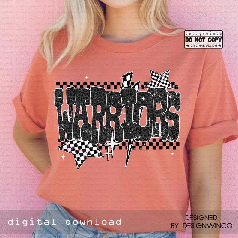 May include: Coral-colored t-shirt with the word "WARRIORS" in a black and white checkered design. The design includes stars and lightning bolts. The shirt has rolled-up sleeves and is made of a soft material.