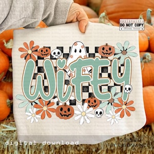 May include: A beige graphic tee featuring the word "Wifey" in teal and brown, surrounded by orange and white flowers, jack-o'-lanterns, skulls, and a ghost. The design has a checkered background and the text "digital download".