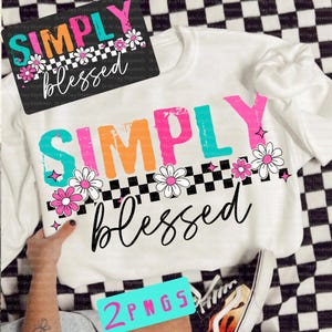 May include: White sweatshirt with the words "SIMPLY blessed" in colorful block letters and script. The design includes daisies and a black and white checkered pattern. A matching design is on a black background.