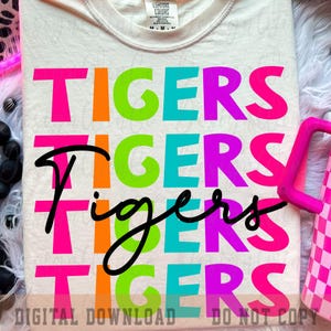 May include: Cream-coloured t-shirt featuring the word "TIGERS" in vibrant pink, orange, green, blue, and purple. The word "Tigers" is also written in a cursive font in black. The words "DIGITAL DOWNLOAD" and "DO NOT COPY" are at the bottom.
