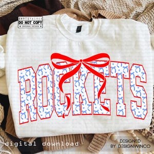 May include: White sweatshirt with the word "ROCKETS" in a bold, red outline font. The letters are filled with a blue bow pattern. A large red bow is over the letters. The words "digital download" and "designed by designwinco" are also visible.