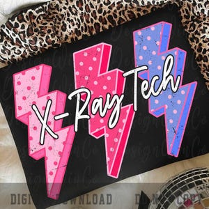 May include: Black t-shirt featuring the text "X-Ray Tech" with pink and blue lightning bolt graphics. The lightning bolts have a polka dot pattern. The shirt is on a leopard print background.
