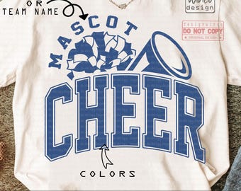 May include: Cream-colored t-shirt with a blue design that says "MASCOT CHEER". The design includes a megaphone and a mascot graphic. The shirt also has the text "COLORS" at the bottom. The shirt is a digital download.