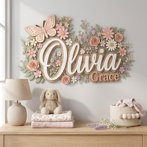 May include: A wall-mounted wooden sign featuring the name Olivia Grace in white and light wood lettering, surrounded by layered paper flowers, leaves, and a butterfly in shades of pink, white, and sage green, creating a floral arrangement.