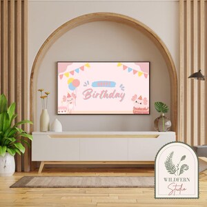 May include: A pink and blue birthday banner with the text "Happy Birthday" and illustrations of axolotls. The banner is displayed on a television screen in a living room setting.