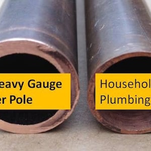 May include: Close-up of two copper pipes side-by-side. The pipe on the left is labeled "Our Heavy Gauge Copper Pole" and the pipe on the right is labeled "Household Plumbing Pipe".