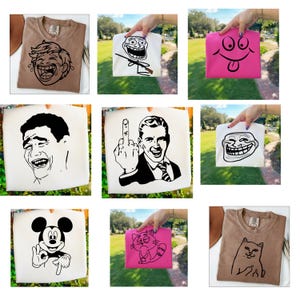 Könnte beinhalten: Eine Sammlung von T-Shirts in verschiedenen Farben, jedes mit einem einzigartigen schwarzen Grafikdesign. Designs umfassen ein lachendes Gesicht, ein Trollgesicht mit einer Waffe, ein rosa Smiley-Gesicht, einen Mann, der den Mittelfinger zeigt, Micky Maus und eine Katze.