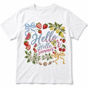 May include: A white short-sleeve t-shirt featuring a colourful graphic print of strawberries, lemons, cherries, watermelon slices, seashells, and two ribbons. The text "Hello Hello Summer" is printed in the centre in a blue and pink script font.