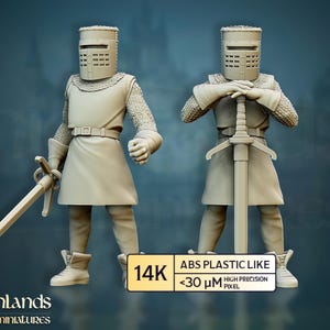 Könnte beinhalten: Zwei beige Ritterfiguren, jede mit Helm, Kettenhemd und Tunika. Einer hält ein Schwert an seiner Seite, der andere umklammert ein Schwert mit beiden Händen. Auf der Basis steht "14K ABS PLASTIC LIKE <30 µm HIGH PRECISION PIXEL".