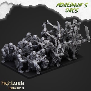 May include: A collection of grey Orc miniatures, posed with weapons such as axes, swords, and bone clubs. The text "MOREDHUN'S ORCS" is above the figures, and "highlands miniatures" is at the bottom. The miniatures are on a dark base.