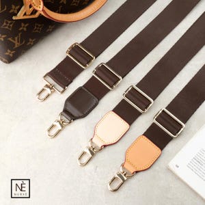 May include: Four brown purse straps with gold-coloured metal hardware. The straps have a dark brown fabric with gold-coloured metal buckles and clasps. Some straps have leather shoulder pads in various colours, including brown and tan. The straps are angled diagonally.
