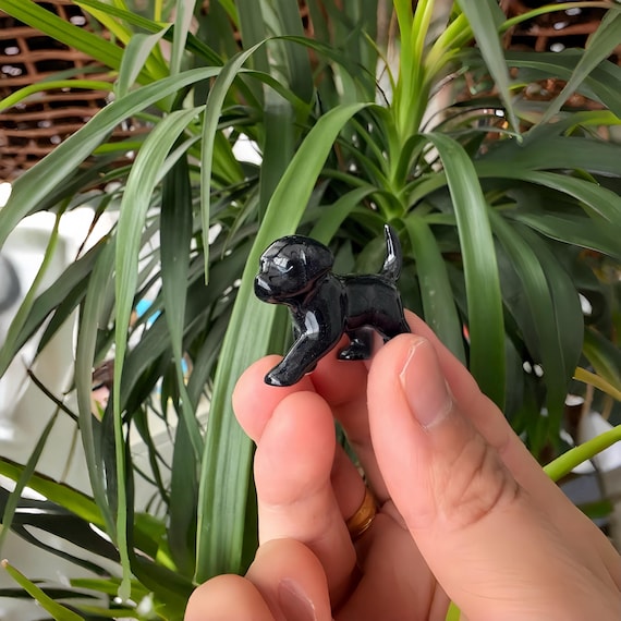 A hand-sculpted porcelain puppy figurine with fine ceramic detail — the kind of tiny art piece that sits on a shelf and starts conversations.