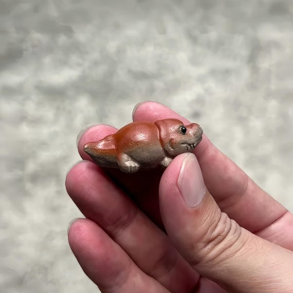 A tiny hand-sculpted Zisha clay crocodile you can pocket or perch on your desk — the kind of hyper-specific miniature that makes people ask 'where did you GET that?'