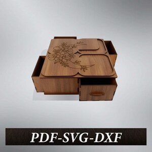 Op de afbeelding: Een lichtbruine houten doos met een bloemenontwerp op het deksel en een lade. De doos heeft een decoratief bloemenpatroon dat in de bovenkant is geëtst. De tekst "PDF-SVG-DXF" staat onderaan.