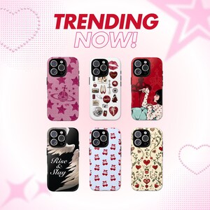 May include: Six different phone cases with various designs. The cases are all for the iPhone 14 Pro. The designs include a pink case with stars and a logo, a white case with a collage of images, a red case with a woman in a white shirt, a black case with a white wing and the words "Rise & Slay", a blue case with a red cherry pattern, and a cream case with a red heart and floral pattern.