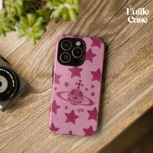 May include: A pink phone case with a white orb and star pattern. The case has a textured fabric-like finish. The text "The Luffle Case" is visible in the top right corner of the image.