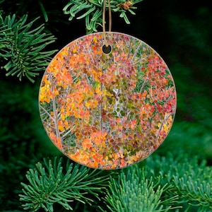 May include: Round Christmas ornament featuring a close-up of a cluster of aspen trees with vibrant fall foliage in shades of yellow, orange, and red.