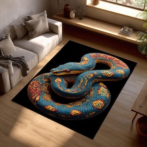 Può includere: Un tappeto arrotolato con un'illustrazione dettagliata di un serpente. Il serpente ha un corpo blu con motivi arancioni e gialli e occhi rossi. Il tappeto è posto su uno sfondo nero, creando un contrasto sorprendente.