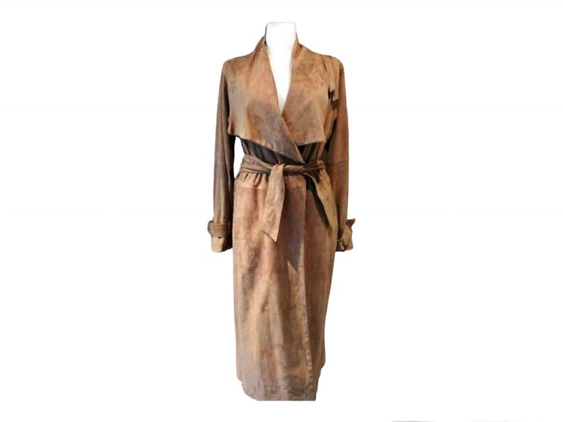 May include: A long brown suede trench coat with a wrap-style collar and a self-tie belt.