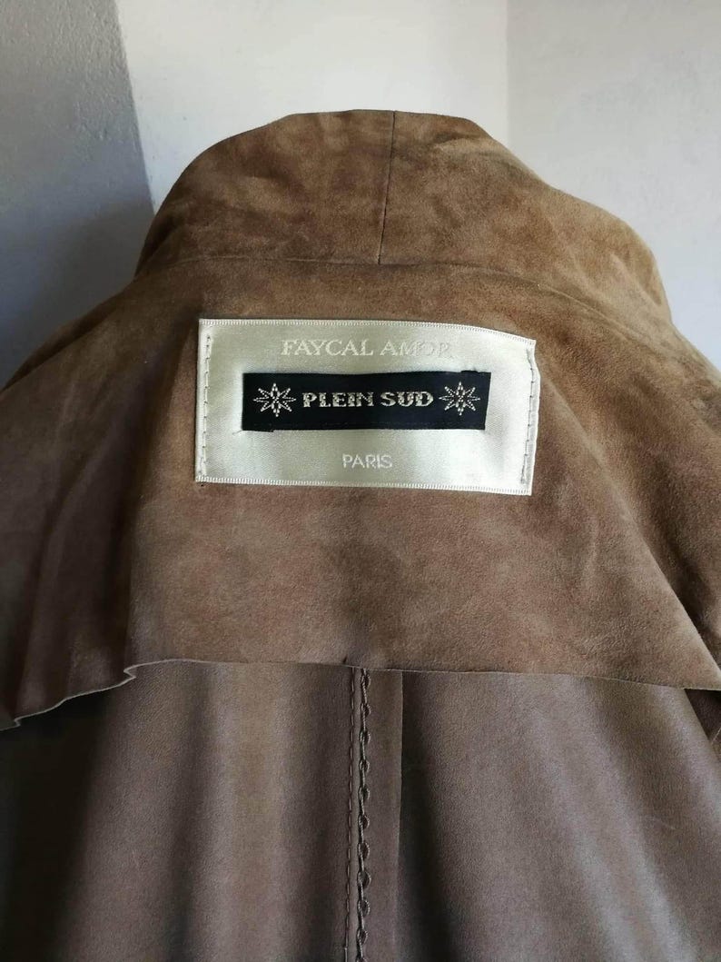 May include: Brown suede jacket with a label that reads "Faycal Amor" and "Plein Sud" Paris.