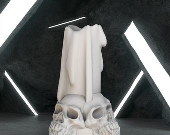Könnte beinhalten: Eine weiße Kerze mit drapiertem Design, die auf einer Basis aus zwei Totenköpfen ruht. Die Kerze hat eine strukturierte Oberfläche und steht vor einem dunklen, strukturierten Hintergrund mit hellem, weißem linearem Licht.